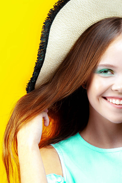 Young happy smiling girl in straw hat over yellow background. Positive, summer, rest - Fotografie, Obrázek