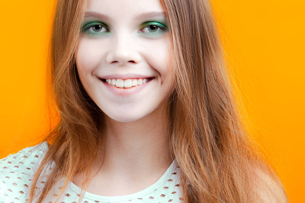 Young cute girl smiling on yellow background. Emotions and beauty - Foto, Bild