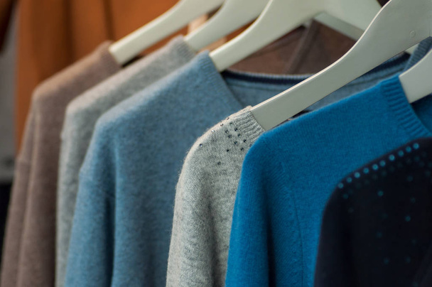 closeup of pullover on hangers in a woman fashion store showroom - Foto, imagen