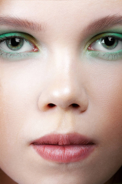 Young cute girl with colorful make-up close-up. Beauty and cosmetics - 写真・画像