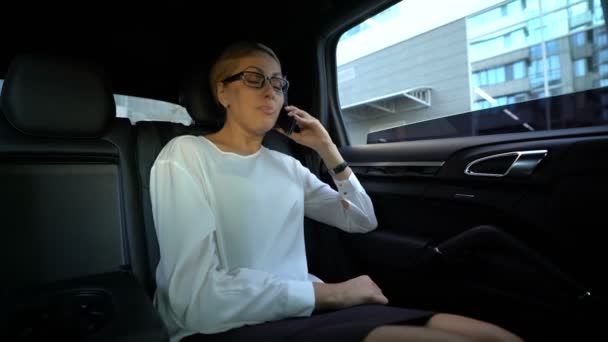 Business woman annoyed with conversation, throwing phone out of car window - Video