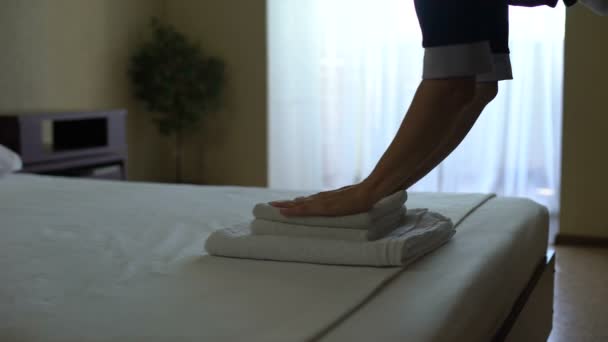 Maid in hotel laying clean towel down and smoothing bed sheets, HoReCa service - Filmagem, Vídeo