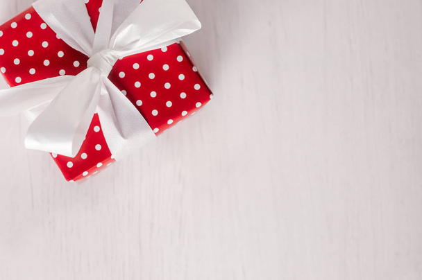 Red gift box with white polka dots, ribbon and bow - Fotoğraf, Görsel