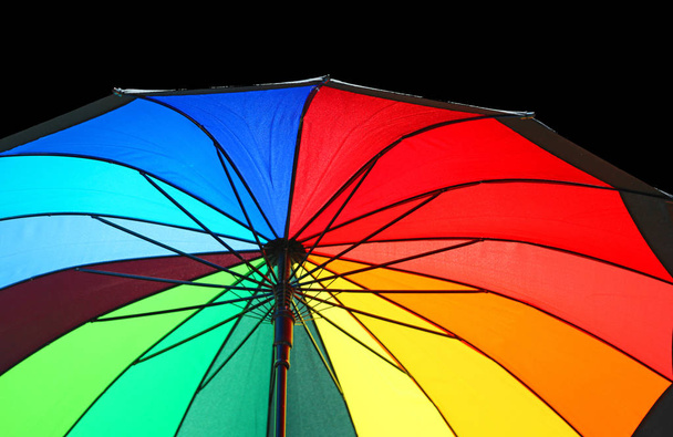 зонтик с цветами радуги открыт, чтобы защитить вас от дождя
 - Фото, изображение