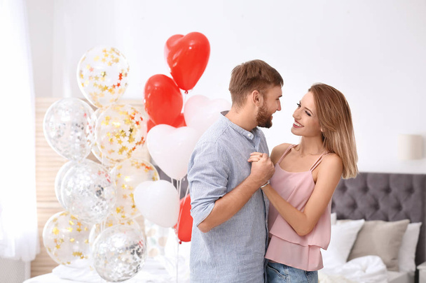 Young couple with air balloons in bedroom. Celebration of Saint Valentine's Day - Valokuva, kuva