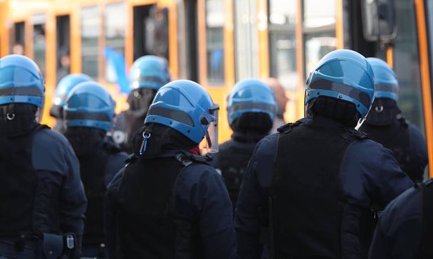 багато поліцейських в автобусах управління бунтами з хуліганами
 - Фото, зображення