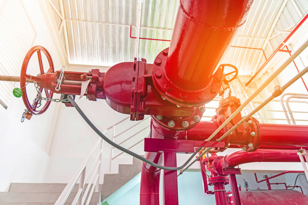 Piros cső, szivattyú rendszer, piros csővezetékek és szelepek tűzvédelmi közelről - Fotó, kép