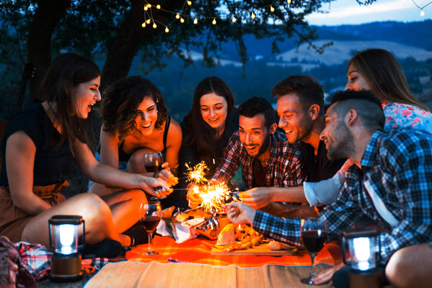 Group of young happy friends having pic-nic outdoors - People having fun and celebrating while grilling ata barbacue party in a countryside - Foto, afbeelding