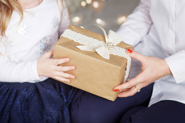 Child's  hands holding gift box. Christmas, hew year, birthday concept. Festive background with bokeh and sunlight. Magic fairy tale - Foto, Bild
