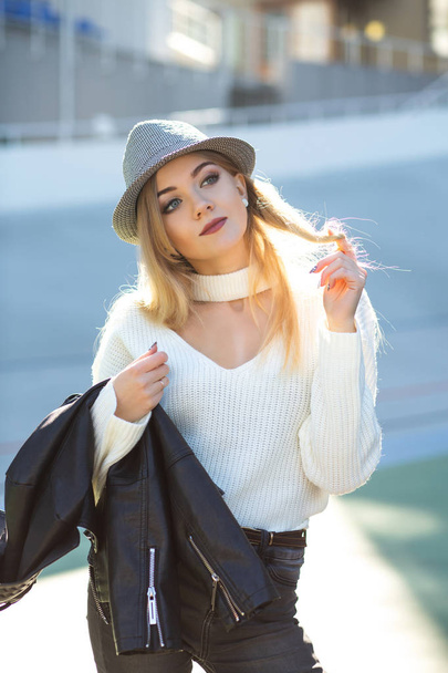 Femme blonde impressionnante portant un chapeau et un pull tricoté, posant dans la journée ensoleillée
 - Photo, image
