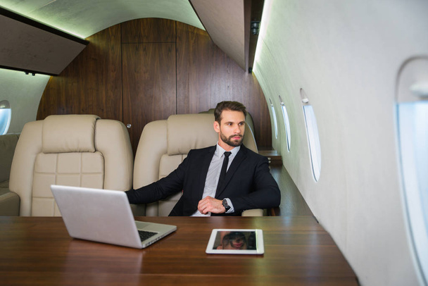 Businessman working while travelling on private jet - Portrait of business people taking a first class flight for work, concepts about business and mobility - Foto, Imagem