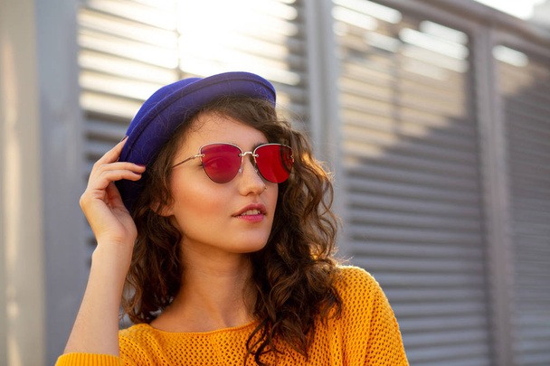 Mavi şapka ve güneş gözlüğü güneş parlama ile poz giymiş şık kadın sokak portresi. Metin için yer - Fotoğraf, Görsel