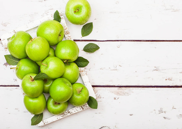Green healthy organic apples in vintage box on wood background  - Fotó, kép