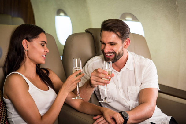 Happy couple travelling on a luxury private jet - Young adults travel on a first class flight, concepts about travel and lifestyle - Foto, Imagem