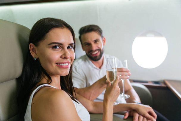 Happy couple travelling on a luxury private jet - Young adults travel on a first class flight, concepts about travel and lifestyle - Foto, immagini