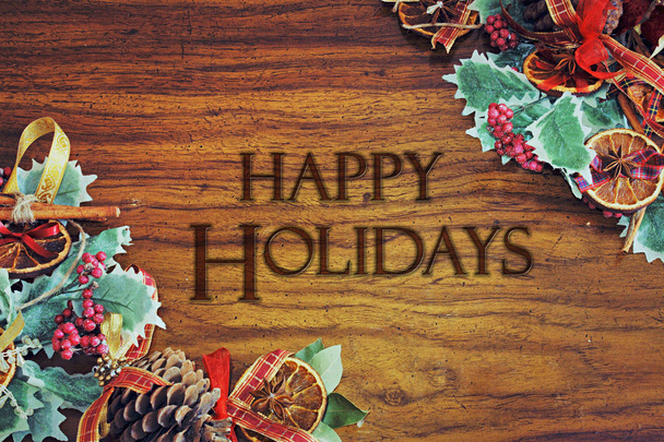 Warme kerst thema wenskaartsjabloon met xmas boom decoratie frame op een houten tafel achtergrond - "Happy Holidays" bericht perfect voor gebeurtenis posters of uitnodigingen - Foto, afbeelding