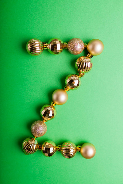 Letra Z hecha de juguetes de Navidad sobre fondo verde. ABC hecho de bolas de oro
 - Foto, imagen