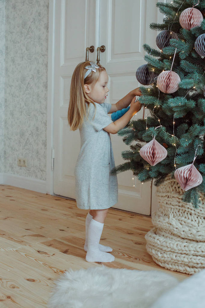 Little girl decorating a christmas tree - Foto, afbeelding