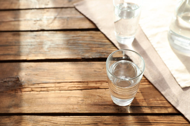 Glassware of fresh water on wooden table. Space for text - Φωτογραφία, εικόνα