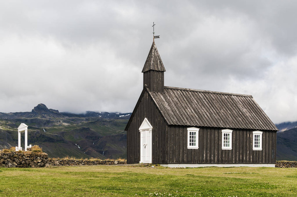 SNAEFELLSNES, ISLANDIA - AGOSTO 2018: Iglesia Budakirkja en la aldea de Budir
. - Foto, imagen