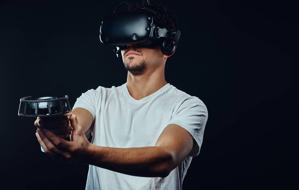 Man met borstelharen gekleed in een wit overhemd spelen met VR-bril. - Foto, afbeelding