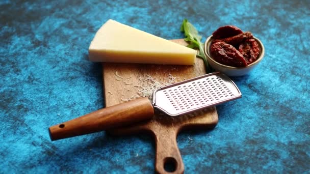 Parmesan Cheese and Grater Above. an above view of a block wedge of  parmesan cheese with shredded pieces all around and a metal cheese grater  on a cutting board Stock Photo
