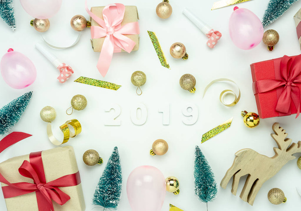 Table top view of Merry Christmas decorations & Happy new year 2019 ornaments concept.Flat lay essential difference objects text & gift box with decor on modern wooden white background. - Фото, изображение