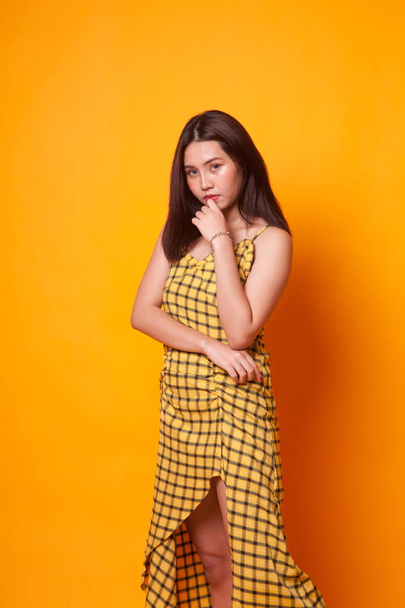Portrait of beautiful young Asian woman on yellow background - Foto, Imagem