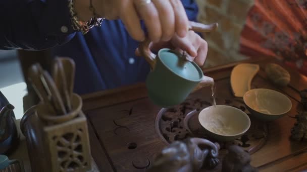 Man gieten van groene thee van theepot naar Gaiwan op traditionele Chinese thee ceremonie. - Video