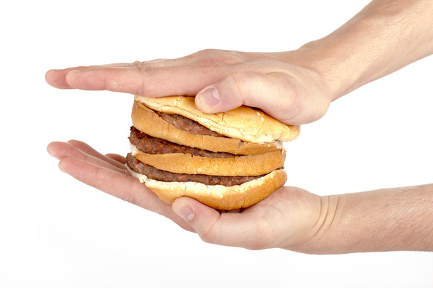 uma mão pressionando o hambúrguer
 - Foto, Imagem