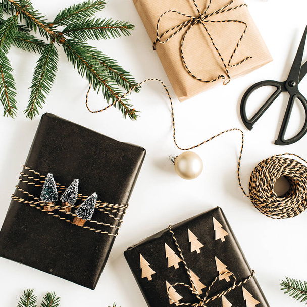 Weihnachten / Neujahr festliche Komposition mit geschmückten Geschenkboxen, Tannenzweigen auf weißem Hintergrund. flache Lage, Draufsicht. - Foto, Bild