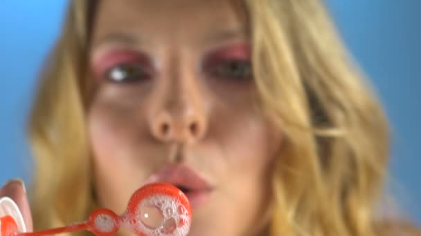 Young woman blowing soap bubbles, back to childhood, good mood, close-up view - Metraje, vídeo