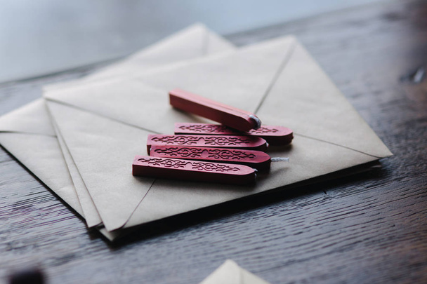 Envelope with stamp and wax on wooden table - 写真・画像