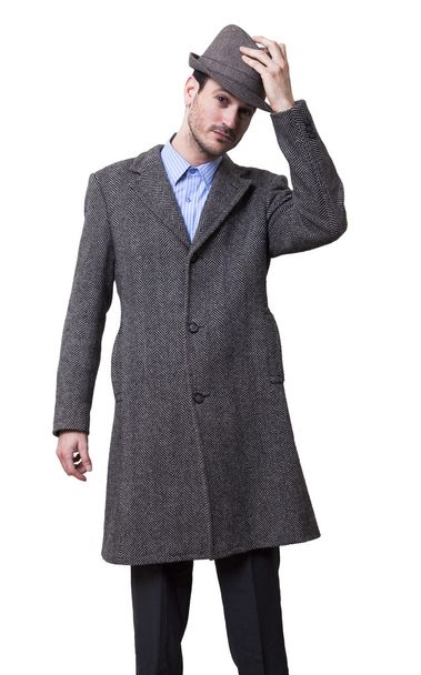 Un maschio adulto che indossa un cappotto e alza il cappello
 - Foto, immagini