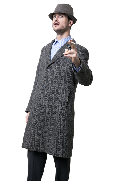 Une personne vêtue d'un manteau gris et d'un chapeau gris ombrageant ses yeux
 - Photo, image