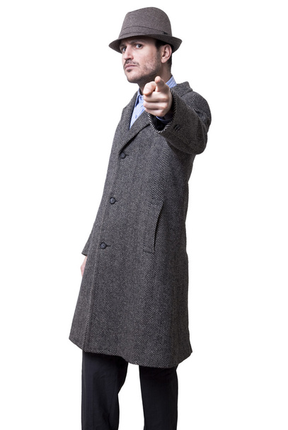 Uma pessoa vestida com um sobretudo cinza e um chapéu cinzento
 - Foto, Imagem