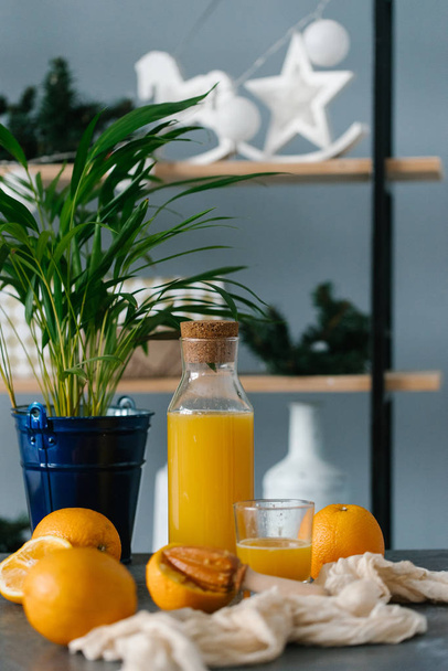 Üveg házi frissen facsart narancslével, a konyhaasztalon  - Fotó, kép