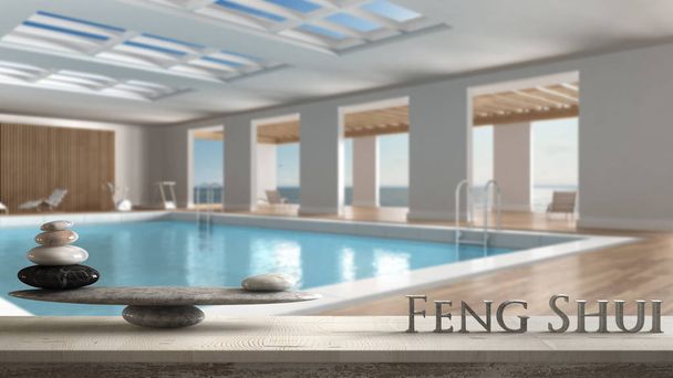 Wooden vintage table shelf with stone balance and 3d letters making the word feng shui over swimming pool indoors with big panoramic windows, zen concept interior design - Photo, Image