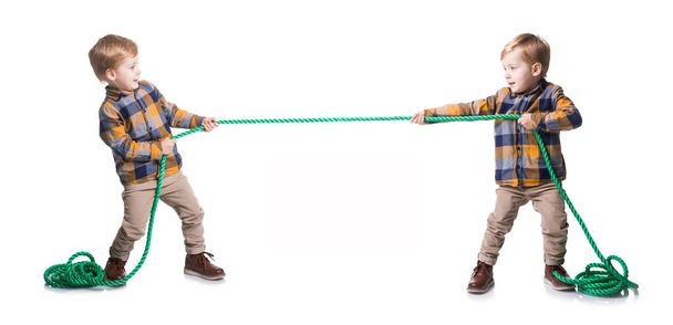 The same kid pull the the rope on a white background - Foto, Bild