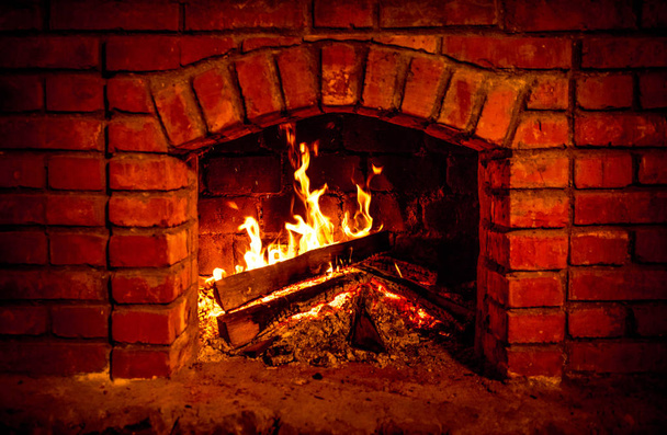 Otoño o invierno chimenea ardiente acogedor concepto de noche de cerca. Primer plano de la quema de leña en la chimenea. Enfoque selectivo
 - Foto, imagen