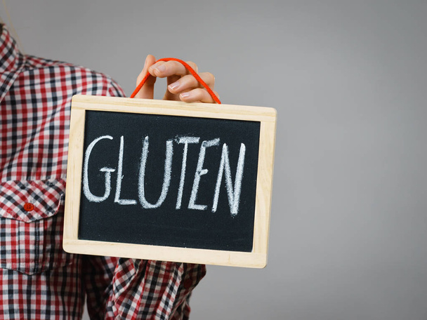 Woman holding small black board with gluten sign. Bakery and bread allergy problem. - Foto, Imagem