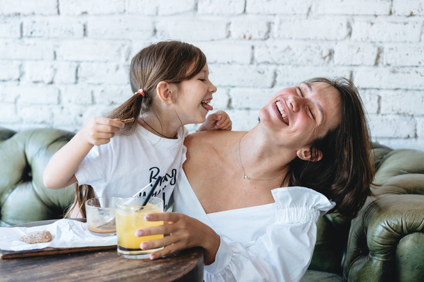 Mom and her little girl have fun on the couch - Photo, Image