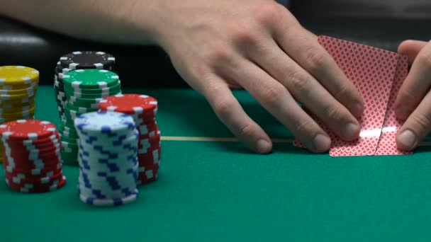 People playing poker, man looking at his cards and pushing chips, all-in - Metraje, vídeo
