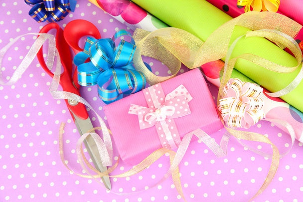 Rolls of Christmas wrapping paper with ribbons, bows on color background - 写真・画像