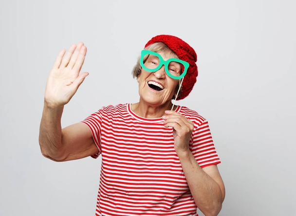lifestyle, emotion and people concept: funny grandmother with fake glasses, laughs and ready for party - Foto, imagen