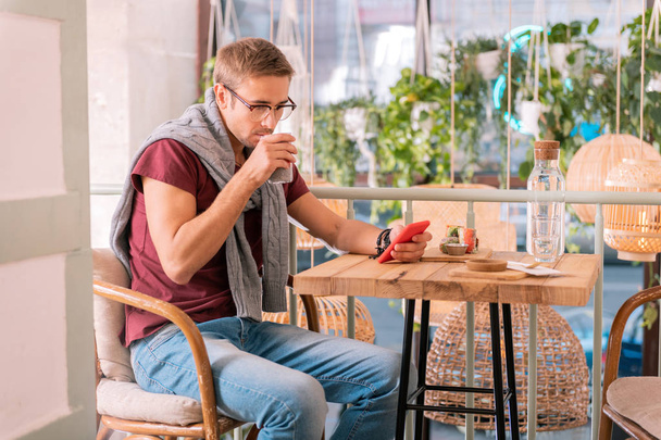 Guapo freelancer sintiéndose aliviado desayunando en cafetería
 - Foto, imagen