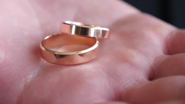bruidegom houdt in zijn hand vak van goud bruiloft ringen, close-up - Video