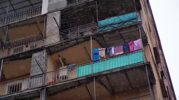 Poor district of the city. Clothes hanging on a clothesline in a building during the rain - Video