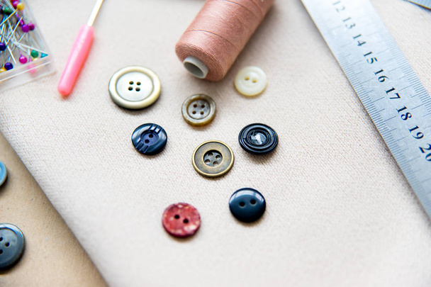 set of sewing tools - scissors, needles, buttons, thread on a table - 写真・画像