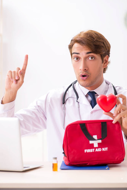 Junger Arzt mit Verbandskasten im Krankenhaus - Foto, Bild